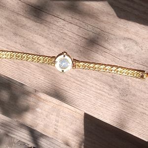 Gold quartz watch missing one diamond